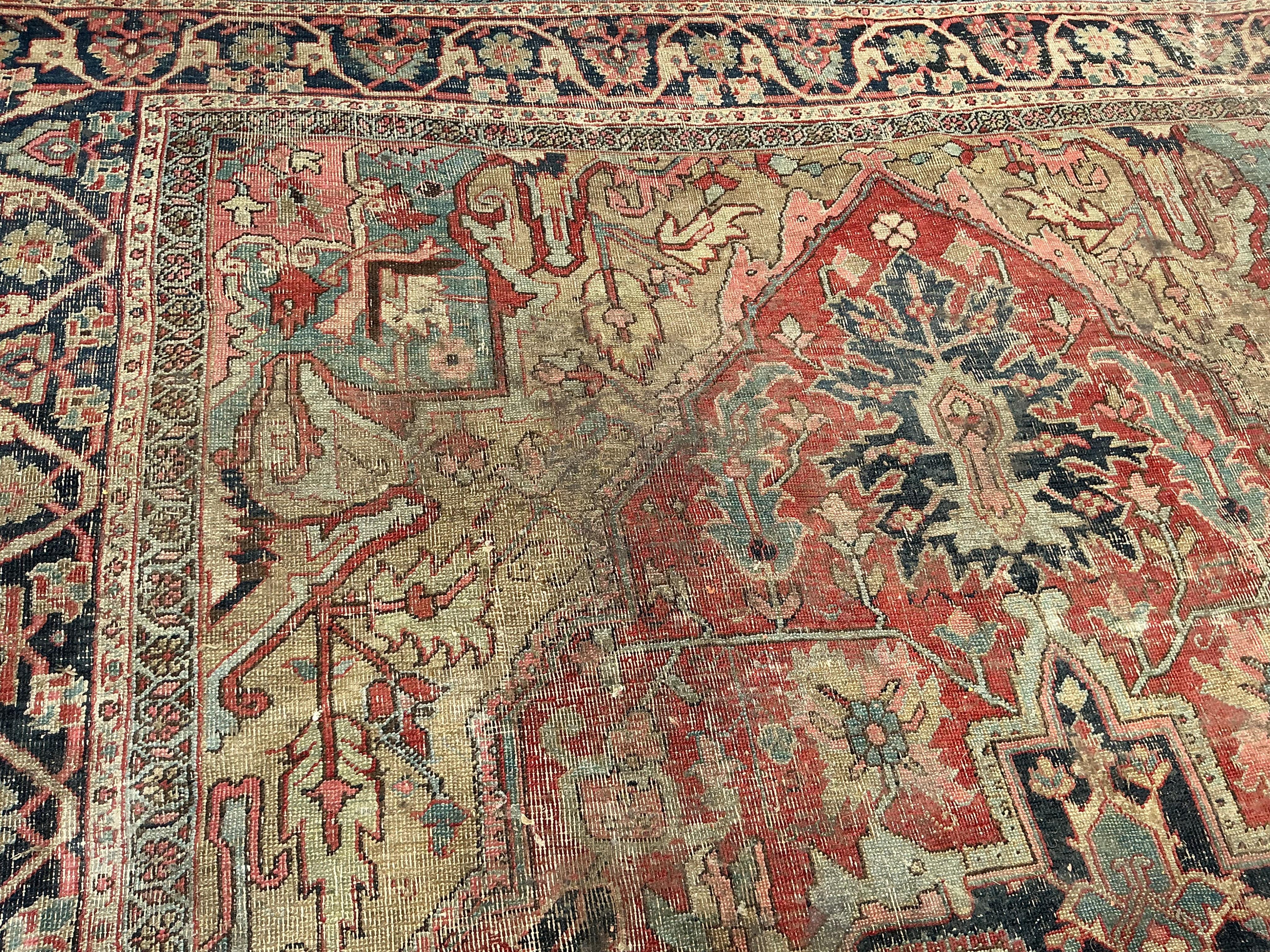 An antique Heriz pink ground carpet, worn and lacking a piece to one corner, 365 x 255cm